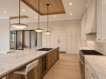 White oak kitchen island and warm stone countertops beside warm white cabinetry
